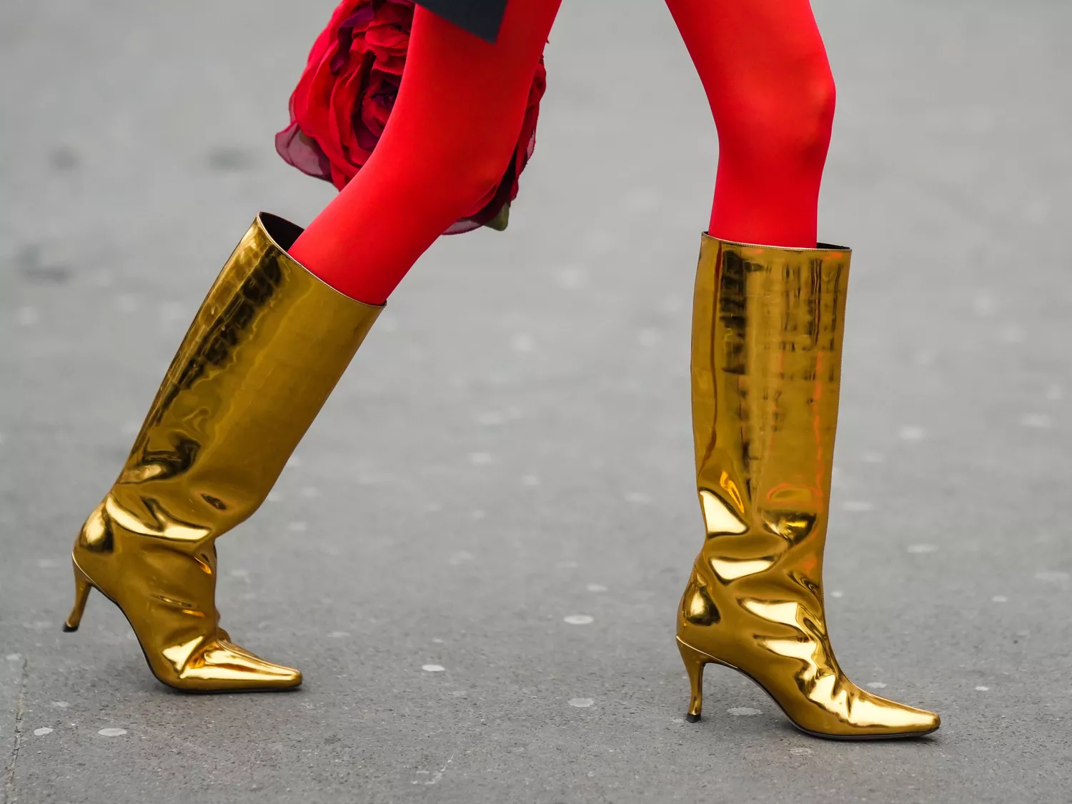 A woman wears one of fall's most wearable NYFW shoe trends for fall: gold boots.